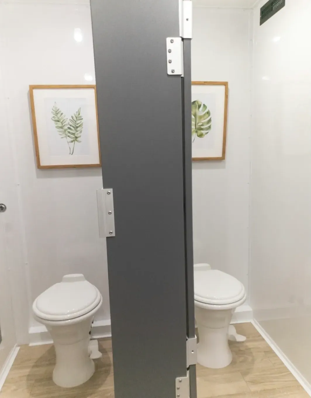 A bathroom with two toilets and a mirror.