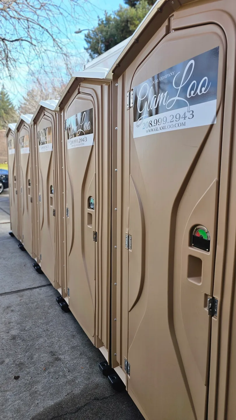 A row of portable toilets on the side of a road.